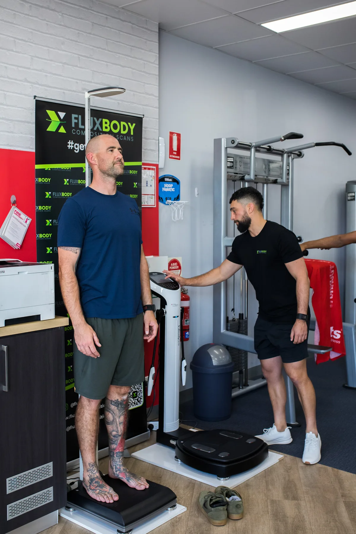 Ayden scanning a gym member on the InBody570 beside the FluxBody banner